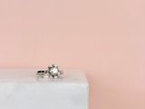 une bague de fiançailles posée sur un bloc de marbre blanc