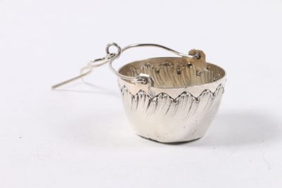 tasse plaquée argent à laquelle est suspendue une cuillère sur le côté