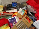 a pile of books on a bed with a red blanket