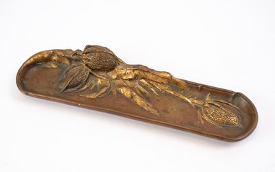 plaque en laiton ornée d'un oiseau et de fleurs sur un fond blanc