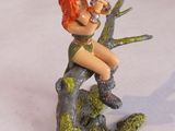 une figurine représentant une femme assise sur une branche d'arbre
