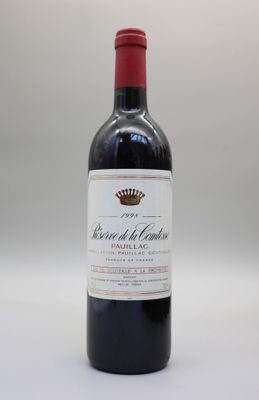 une bouteille de vin rouge posée sur une table blanche