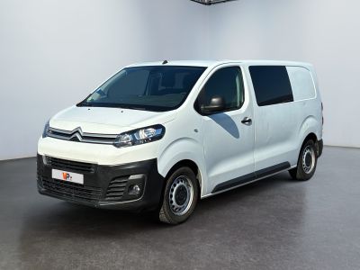 La camionnette blanche est garée dans une grande pièce.