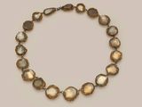a gold and silver necklace with oval shaped stones