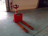 un chariot élévateur rouge garé dans un garage, à côté d'une porte de garage