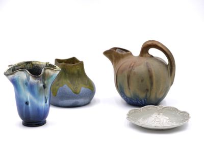 three small vases and a plate on a white surface
