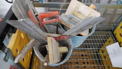 a bucket full of tools sitting on top of a shelf
