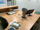 a desk with a computer monitor, books, and other items on it