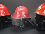 three red fire helmets sitting next to each other on a black background