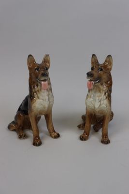 deux figurines de chiens assis l'une à côté de l'autre
