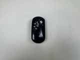 a small black object with flowers in it on a white surface