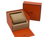 an orange box with a watch inside of it on a white surface