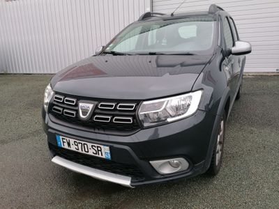 vue de face d'une Dacia noire garée devant un immeuble