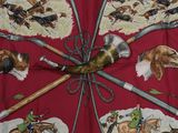 a red umbrella with a picture of horses and dogs on it