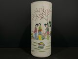 un vase blanc avec un tableau posé sur une table