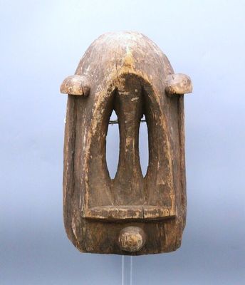 a wooden sculpture of a face on a glass stand