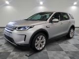 un Land Rover argenté garé dans un garage au sol carrelé