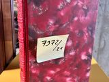 a red book with a sticker on it sitting on a yellow table