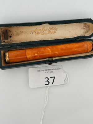 an orange pen in a black case on a white table