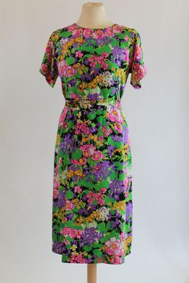 a dress on a mannequin stand with flowers on it