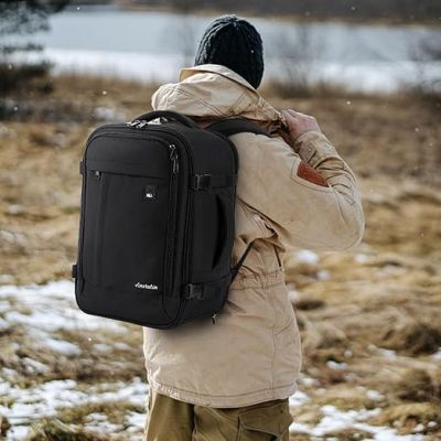 un homme avec un sac à dos, debout dans la neige