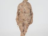 sculpture of a woman standing on a wooden base with a white background