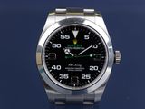 rolex watch with a black dial and green hands on a blue background