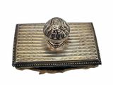 silver plated box with a ring on top of it on a white surface