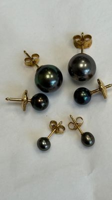 three pairs of black pearl earrings and a pair of gold earrings