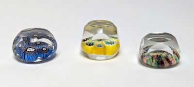 three different colored glass beads sitting on top of a white surface