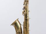 an old brass saxophone sitting on top of a white surface