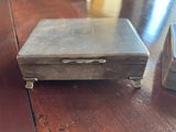 a small metal box sitting on a wooden table