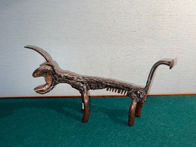 statue of a dog with a comb in its mouth on a green carpet