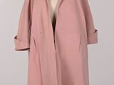 un manteau rose sur un mannequin sur fond blanc