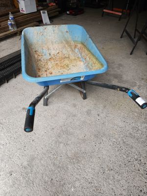 a blue wheelbarrow with a handle on it in a garage