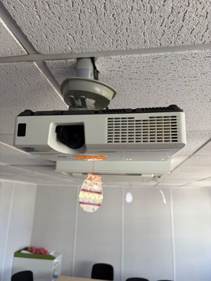 a projector hanging from the ceiling in a room