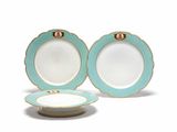 deux assiettes bleues et blanches, ornées de bordures dorées sur fond blanc