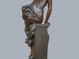 bronze statue of a man sitting on a pedestal with his back to the camera