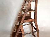 a wooden ladder that is leaning against a white wall