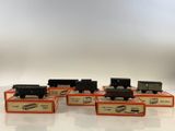 six toy trains are lined up in a row on a white surface