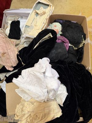 une boîte remplie de vêtements et de chaussures posée par terre
