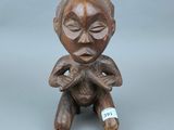 deux petites figurines en bois représentant une femme avec un bébé sur les genoux