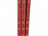 trois livres rouges superposés sur une surface blanche