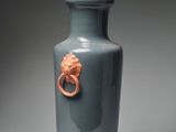 a blue vase with a gold lion head on it