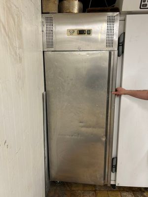 un homme debout devant un réfrigérateur dans une cuisine