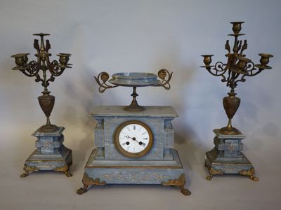 trois types différents d'horloges et de lustres posés sur la table