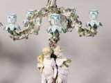 pair of porcelain figurines of angels and cherenshes on a stand