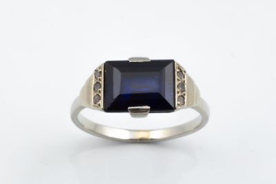 a close up of a ring with a blue stone in it
