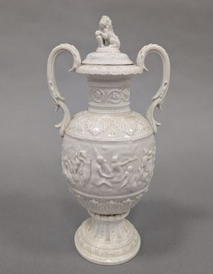 un vase blanc surmonté d'un oiseau