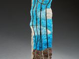 sculpture en pierre bleue et blanche sur laquelle figure une rangée d'arbres